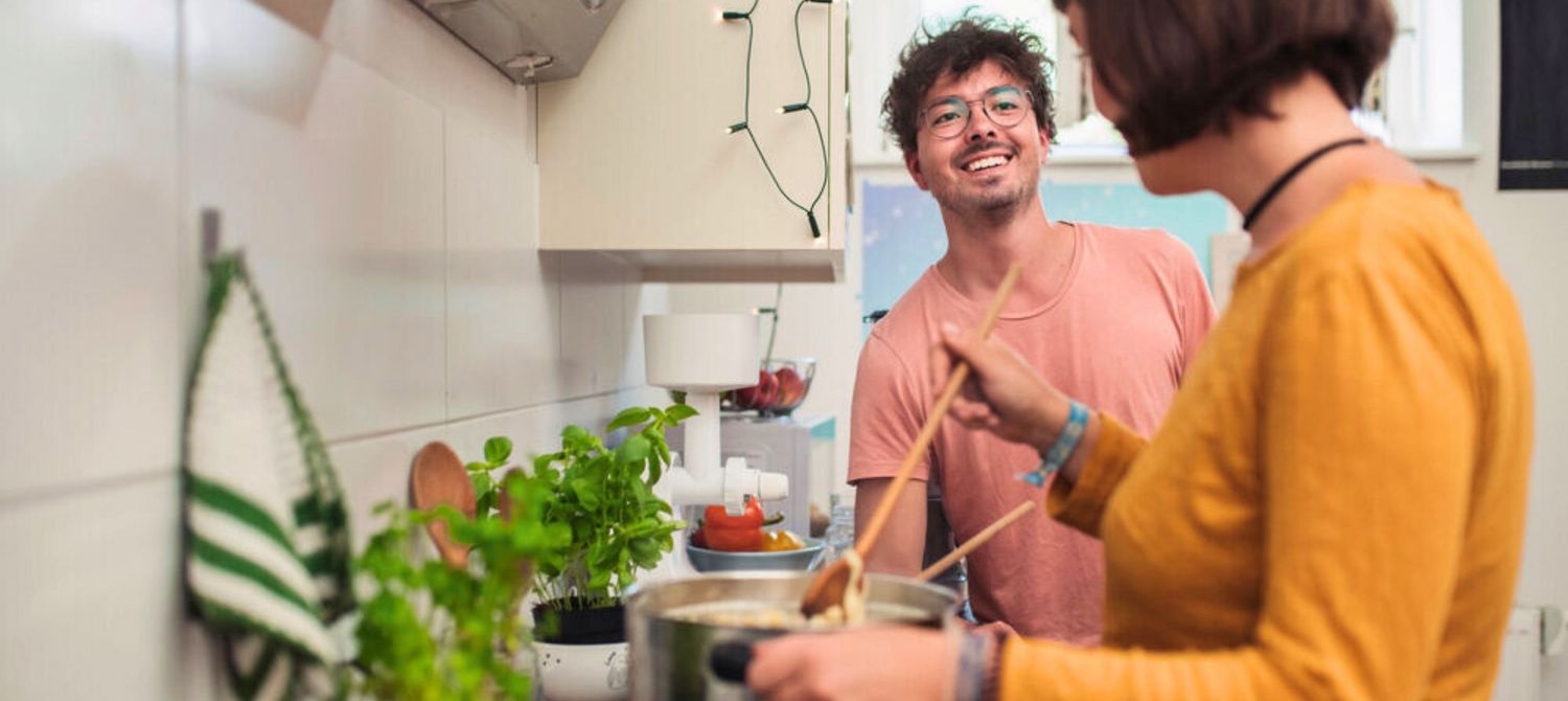 Zwei junge Menschen kochen in einer Küche.